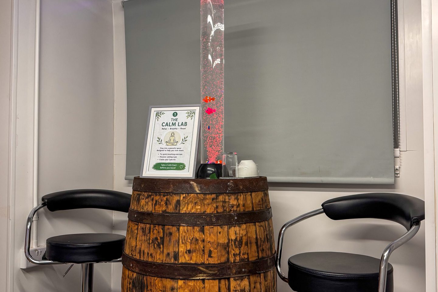 A quiet corner at Mwanga with two stools, a barrel table and a bubble tube.