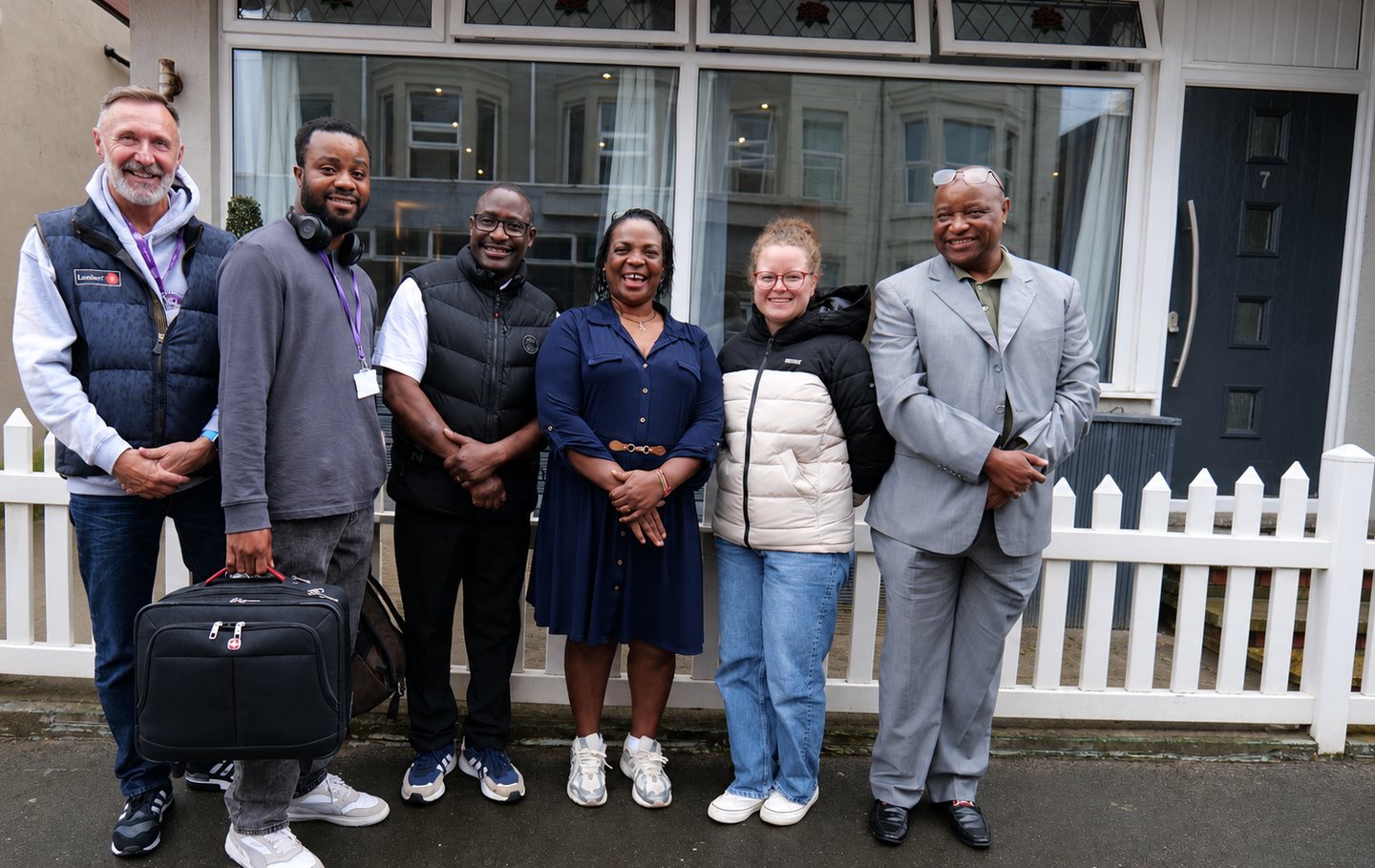 Six colleagues standing together outside a building in Blackpool, several wearing lanyards.
